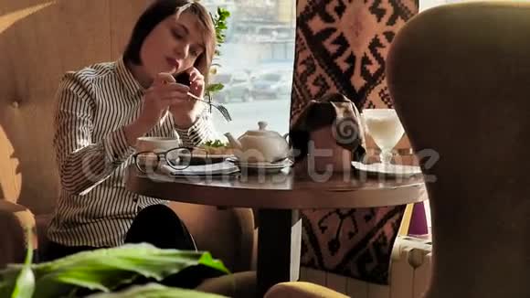 美丽的女人在午餐时休息坐在咖啡馆里商务午餐慢动作视频的预览图