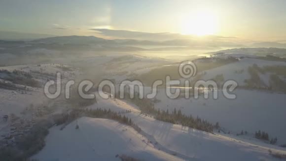 鸟瞰白雪覆盖的山脉冬季的乡村景观飞越喀尔巴阡山的一个村庄视频的预览图