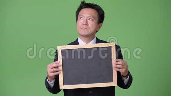 成熟的日本商人在绿色背景下视频的预览图