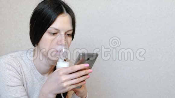 使用雾化器和吸入器进行治疗年轻女性通过吸入面罩吸入侧视视频的预览图