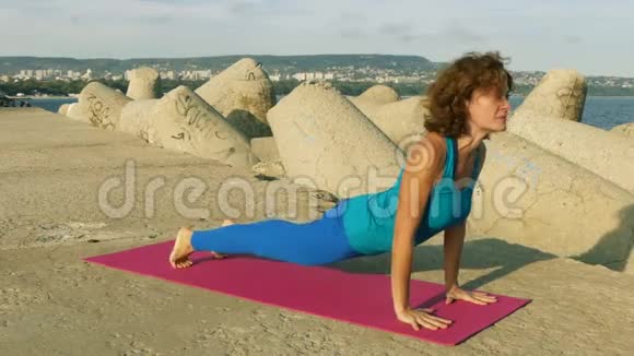 日落时分在海滩上练习瑜伽的女人视频的预览图