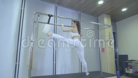 普拉提穿着白色衣服的女人在健身房里练习举重运动所有系列编号01234567890001视频的预览图