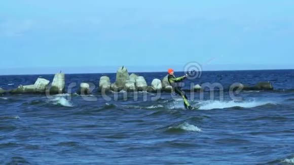慢动作一个雄风筝冲浪者在水面的木板上滚动视频的预览图