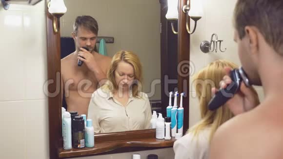 美丽的夫妻男人和女人一起在镜子前的浴室里洗4K慢动作女人是视频的预览图