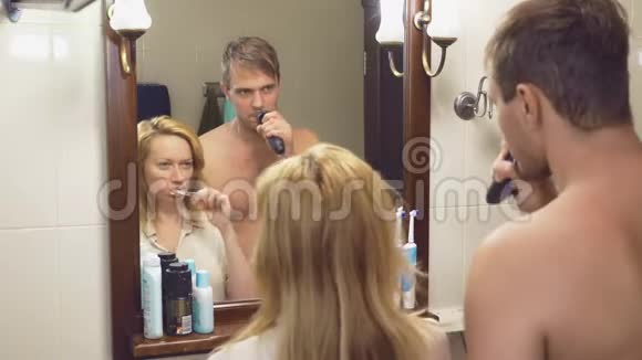 美丽的夫妻男人和女人一起在镜子前的浴室里洗4K慢动作女人是视频的预览图