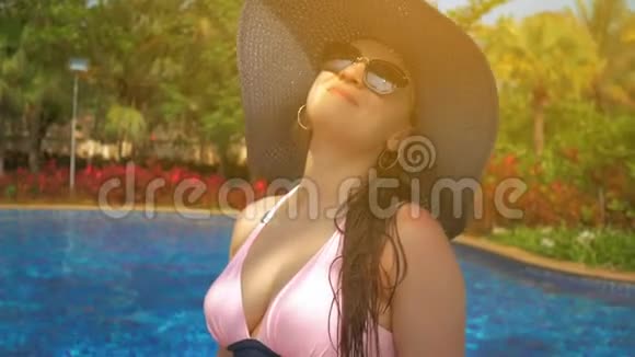 游泳池边戴蓝帽子的漂亮女孩夏日阳光视频的预览图