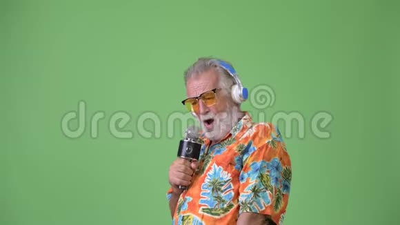 英俊的大胡子游客准备在绿色背景下度假视频的预览图