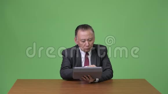 成熟的日本商人与数码平板电脑合作视频的预览图