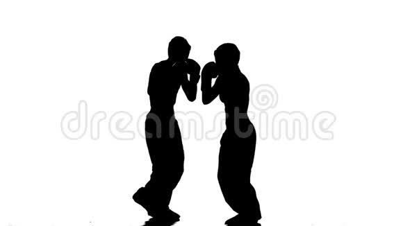 女孩在踢他们为踢拳击而争吵的家伙剪影白色背景视频的预览图