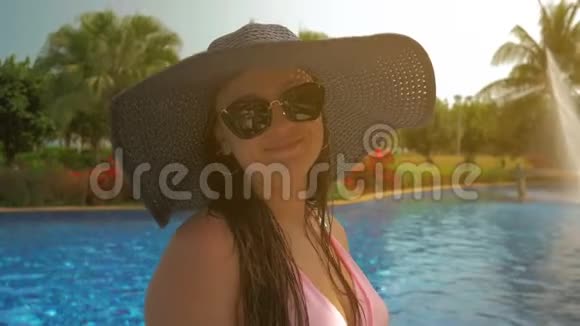游泳池边戴蓝帽子的漂亮女孩夏日阳光视频的预览图