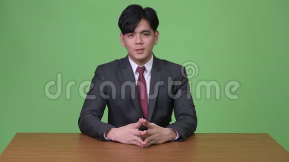 年轻英俊的亚洲商人绿色背景视频的预览图