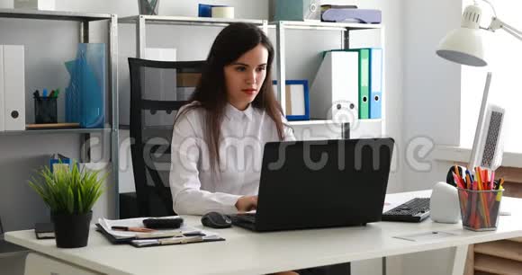 在现代办公室用笔记本电脑工作的女商人视频的预览图