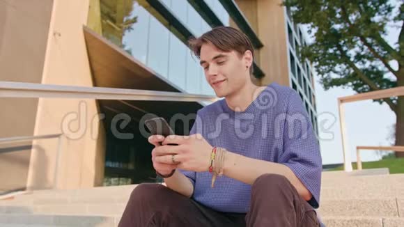 城市中坐着和使用电话的年轻人视频的预览图
