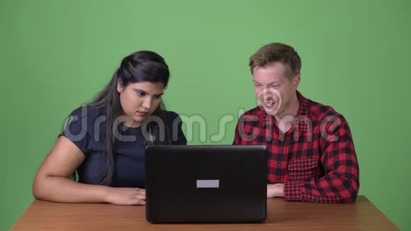 年轻的多民族商业夫妇在绿色背景下在一起视频的预览图