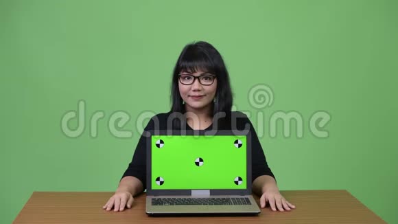 漂亮的亚洲女商人展示笔记本电脑视频的预览图