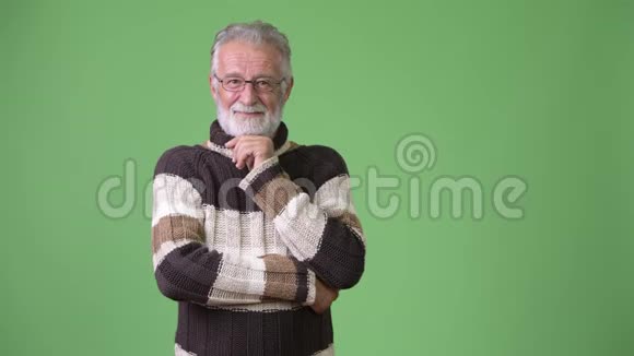 身穿绿色背景暖衣的英俊的大胡子男子视频的预览图