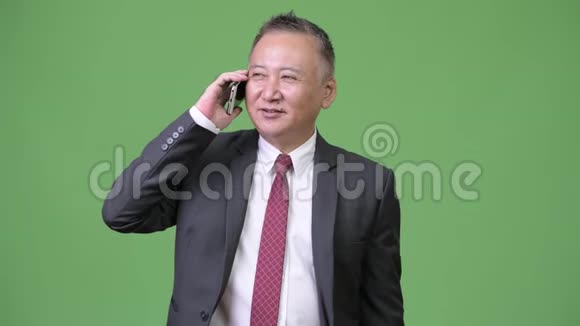 成熟的日本商人使用电话视频的预览图