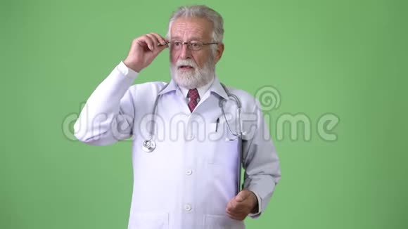 绿色背景下英俊的大胡子男医生视频的预览图