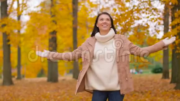 秋天公园里快乐的年轻女人视频的预览图