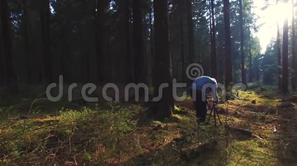 摄影师在春天的寂静森林里拍照视频的预览图