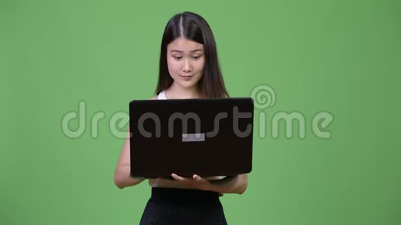 年轻漂亮的亚洲女商人用笔记本电脑视频的预览图