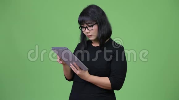 美丽的亚洲女商人用数码平板电脑思考视频的预览图