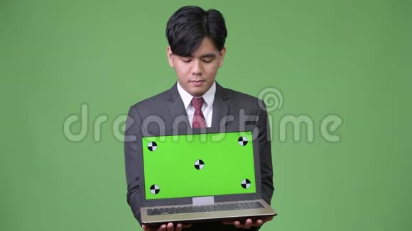 年轻英俊的亚洲商人展示笔记本电脑视频的预览图