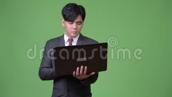 年轻英俊的亚洲商人用笔记本电脑视频的预览图