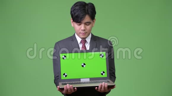 年轻英俊的亚洲商人展示笔记本电脑视频的预览图
