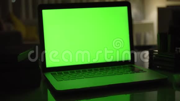带有绿色屏幕的笔记本电脑黑暗的家庭办公室视频的预览图