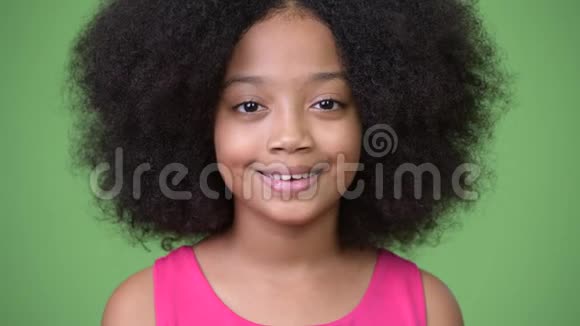 年轻可爱的非洲女孩非洲头发在绿色背景下微笑视频的预览图
