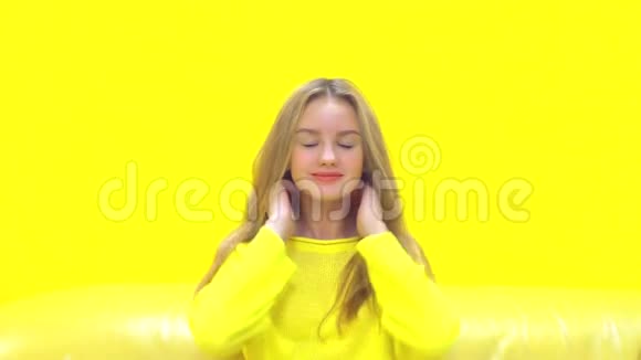 年轻的金发女郎黄色背景视频的预览图