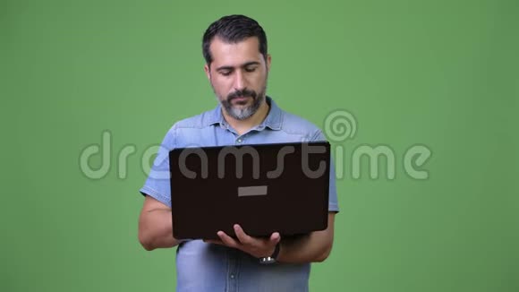 英俊的波斯胡子男人用笔记本电脑视频的预览图