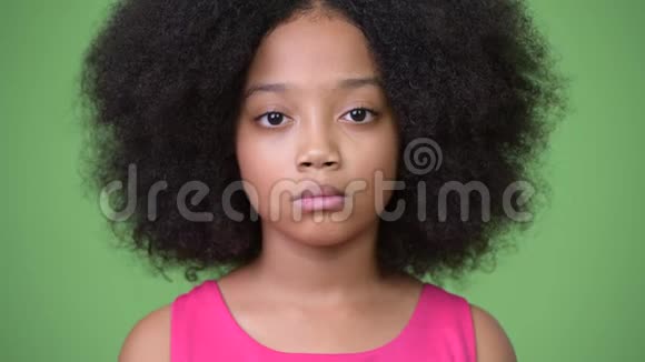 年轻可爱的非洲女孩非洲头发绿色背景视频的预览图