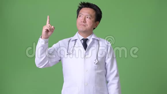 成熟的日本男子医生绿色背景视频的预览图