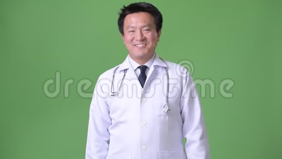 成熟的日本男子医生绿色背景视频的预览图