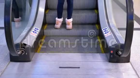 在购物中心乘坐自动扶梯电梯的人的腿视频的预览图