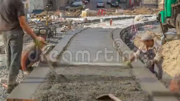 有许多工人和搅拌机的道路施工混凝土工程视频的预览图