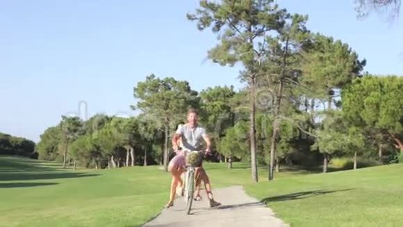 公园骑自行车的情侣共享单车视频的预览图