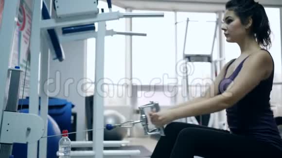 健康的身体女性在体育场馆的模拟器上进行运动视频的预览图