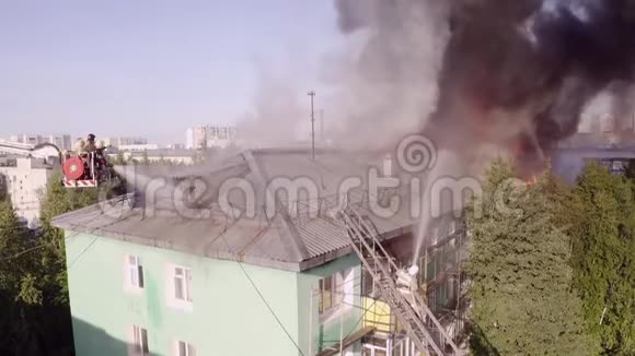 楼梯上的消防员扑灭了一栋住宅高层建筑屋顶上的火灾顶部视图视频的预览图