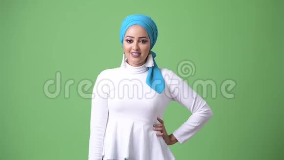 年轻漂亮的非洲穆斯林妇女带绿色背景的彩色钥匙视频的预览图