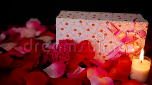 情人节礼物盒蜡烛燃烧和玫瑰花瓣装饰录像视频的预览图