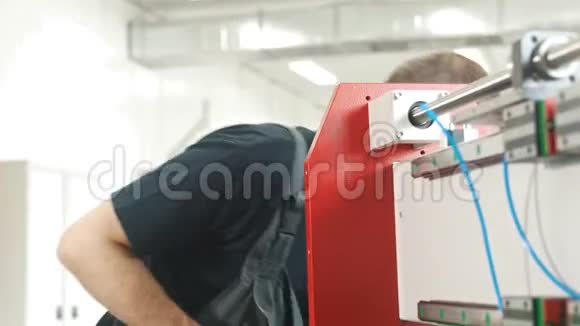 穿工作服的电工在工厂里使用能源面板和机械设备视频的预览图