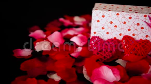 情人节礼物盒蜡烛燃烧和玫瑰花瓣装饰录像视频的预览图