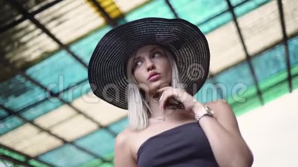 戴着帽子的迷人微笑的年轻女子的肖像时尚时尚的穿着视频的预览图