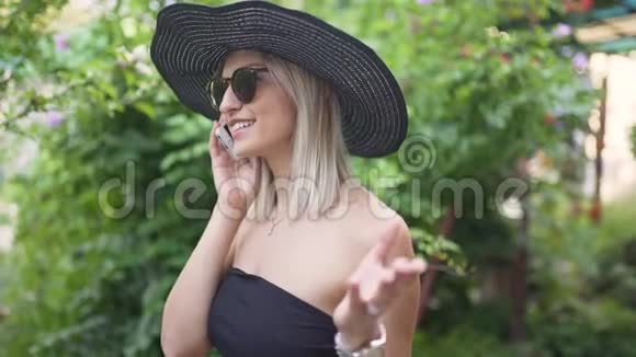 年轻时尚的漂亮女人戴着帽子使用智能手机女人在打电话视频的预览图
