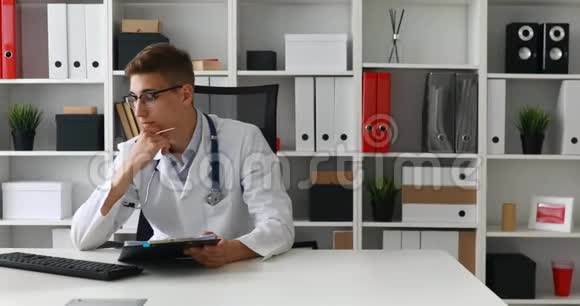 年轻的医生在电脑上处理文件视频的预览图