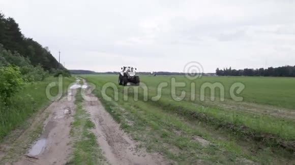 灰色拖拉机骑在绿色的田野上视频的预览图