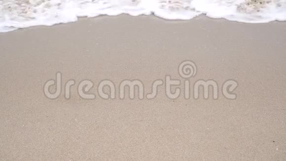 白色的海水泡沫在潮湿的沙滩上慢速视频视频的预览图